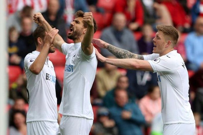 Swansea City's striker Fernando Llorente (C) celebrates with midfielder Gylfi Sigurdsson (L) and defender Alfie Mawson (R) after scoring the opening goal of the English Premier League football match against Sunderlan May 13, 2017