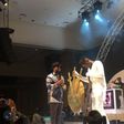 Timaya handing Ycee an artifact