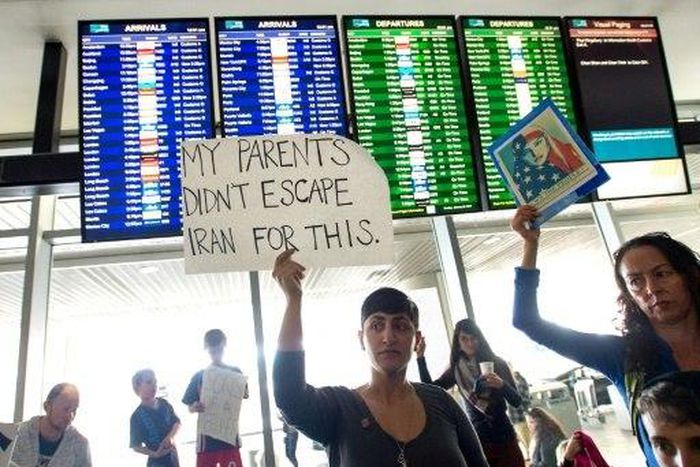 Protesters hold signs up during a protest at San Francisco International Airport in California on January 29, 2017