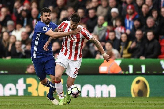 Chelsea's Diego Costa (L) fights for the ball with Stoke City's Geoff Cameron during their English Premier League match, at the Bet365 Stadium in Stoke-on-Trent, on March 18, 2017