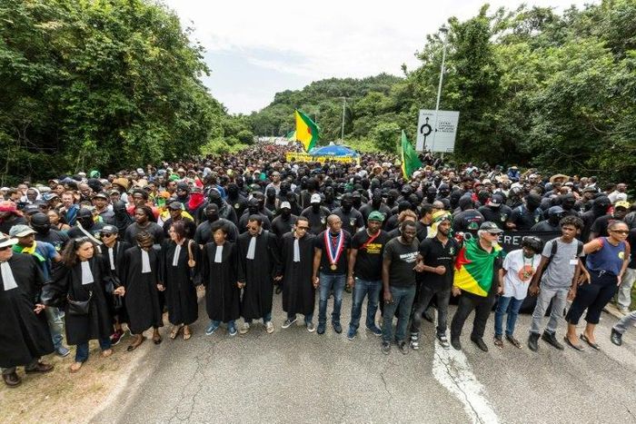 Demonstrators and lawyers stand during a protest over security and the state of the economy near the Centre Spatial Guyanais on April 4, 2017 in Kourou, French Guiana