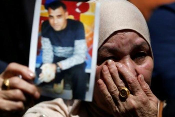 A woman holds the portrait of a Palestinian prisoner during a rally in the West Bank city of Ramallah on April 17, 2017 to show support to hundreds of hunger strikers in Israeli jails