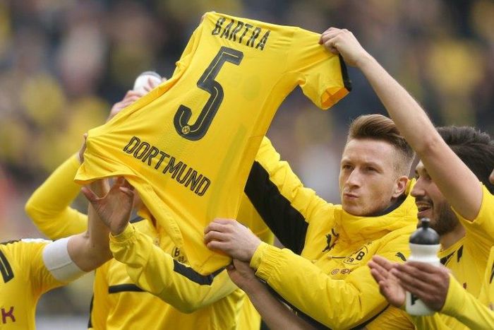 Dortmund's Marco Reus holds the jersey of teammate Marc Bartra who was injured during attack on the team's bus after their German First division Bundesliga match against Eintracht Frankfurt, in Dortmund, on April 15, 2017