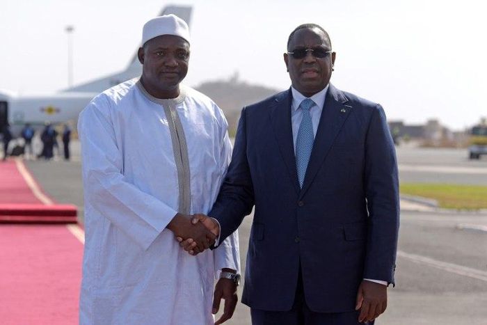 Senegal's President Macky Sall (R) shakes hands with the new President of Gambia Adama Barrow prior to leaving the Senegalese capital Dakar on January 26, 2017