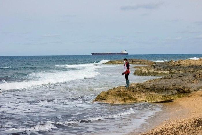 A Libyan Red Crescent volunteer looks for bodies in February 2017