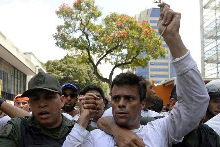 This photo taken on February 18, 2014 shows Venezuelan opposition leader Leopoldo Lopez (R) as he is escorted by the National Guard after turning himself in, during a demonstration in Caracas