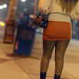 A sex worker walks down a lonely street at night.