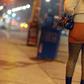A sex worker walks down a lonely street at night.