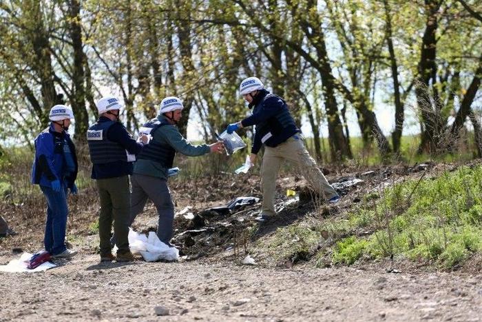 OSCE monitors work near Lugansk on April 25, 2017, to inspect the site where an OSCE patrol vehicle was destroyed by an explosion on April 23