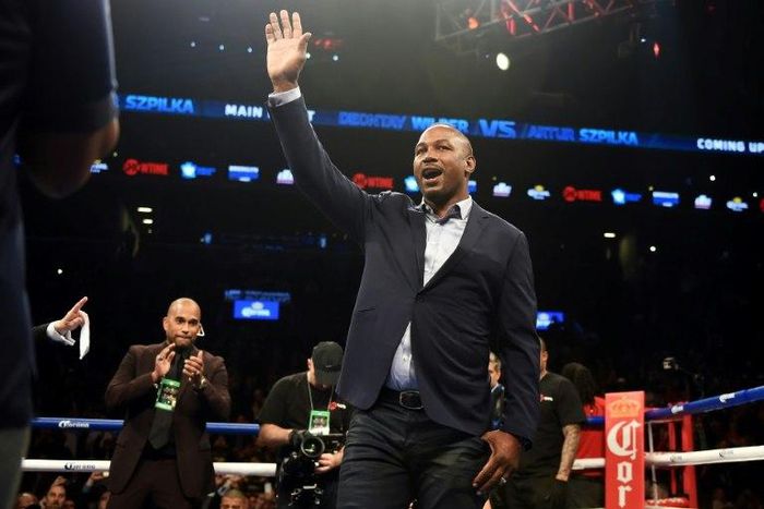 Former heavyweight champion Lennox Lewis (C) waves from the ring at Barclay's Center in Brooklyn, New York, in January 2016