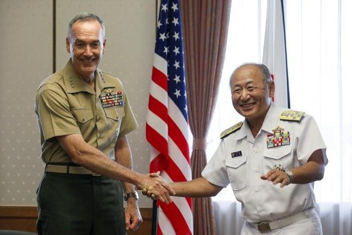 General Joseph Dunford (L), the chairman of the US Joint Chiefs of Staff, shakes hands with Japan's Chief of Staff of Joint Staff Katsutoshi Kawano (R) at the start of their talks at the Defence Ministry in Tokyo
