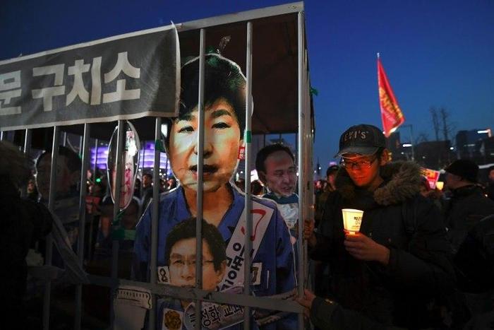 A poster shows Park Geun-Hye behind bars, at a rally in Seoul on March 11, 2017
