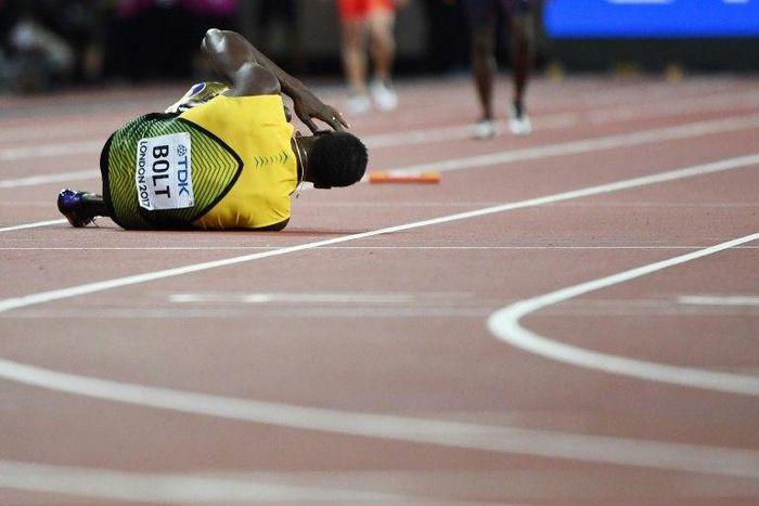 Jamaica's Usain Bolt goes down after pulling up injured in the final of the men's 4x100m relay athletics event at the 2017 IAAF World Championships at the London Stadium in London on August 12, 2017