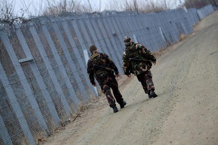 Soldiers patrol along the border fence on the Hungarian-Serbian border in February 2017