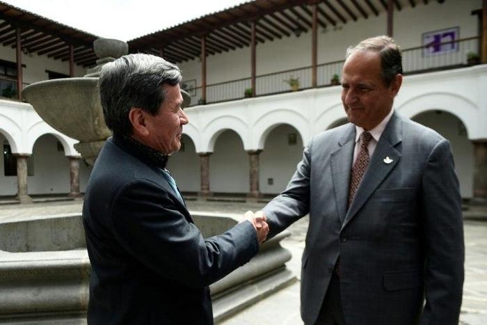 The representative of Colombian guerrilla group ELN, Pablo Beltran (L), and representative of the Colombian government Juan Camilo Restrepo shake hands at the Palacio Arzobispal in Quito where they arrived to hold a meeting on March 3, 2017