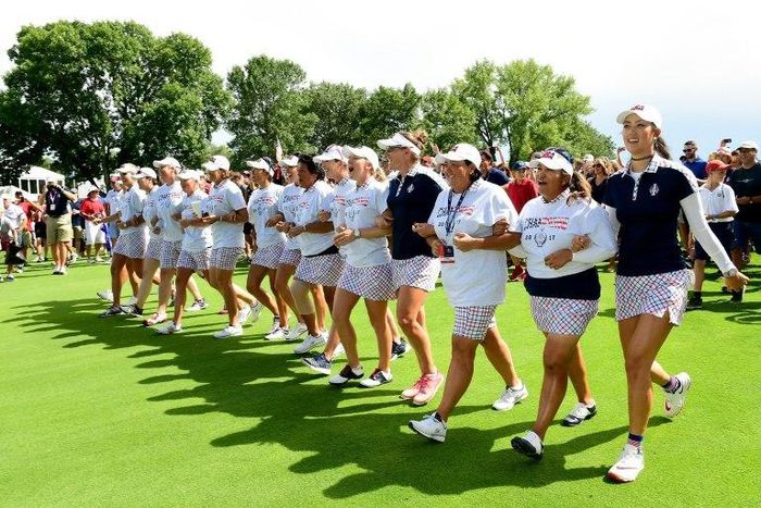 Team USA walk arm and arm up the 18th fairway after beating Team Europe in the Solheim Cup on August 20, 2017