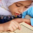 Little girl reading the Quran