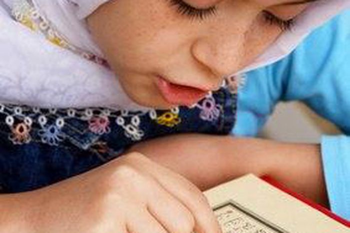 Little girl reading the Quran