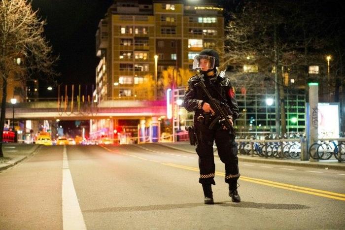 A police officer stands guard near a cordened off area in central Oslo on late April 8, 2017, following the discovery of a 'bomb-like device'