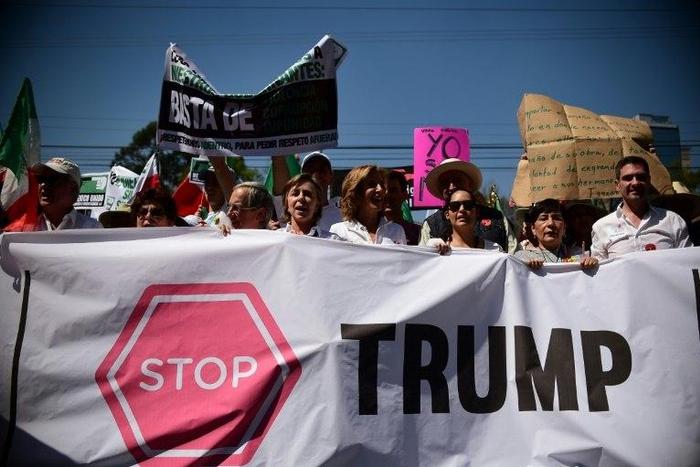 People hold sugns against US President Donald Trump during an anti-Trump march in Mexico City, on February 12, 2017