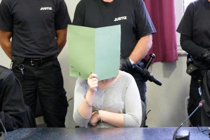 Defendant Xenia I covers her face in a courtroom in Dessau, Germany, on August 4 2017