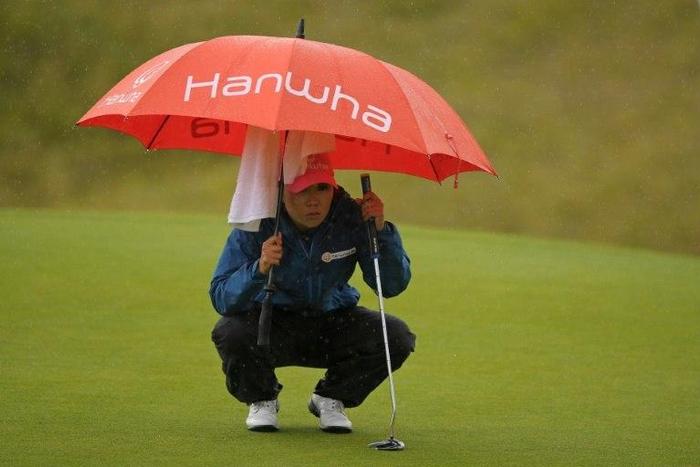 Korea's In-Kyung Kim shelters under an umbrella as she lines up her putt on the 18th green during her second round on day 2 of the 2017 Women's British Open Golf Championship at Kingsbarns Golf Links near St. Andrews, east Scotland, on August 4, 2017