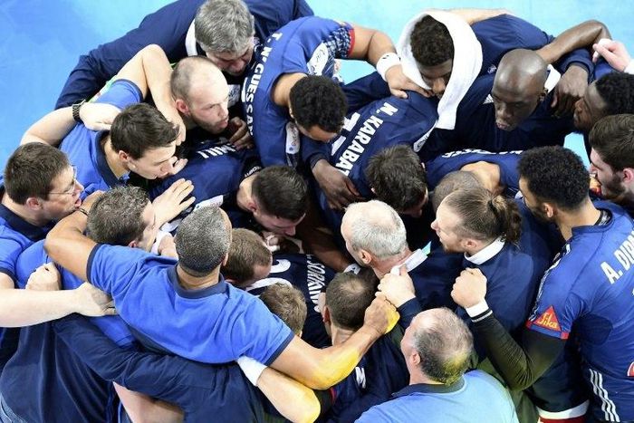 The French national handball team celebrate after winning their semi-final handball match against Slovenia on January 26, 2017 at the AccorHotels Arena in Paris