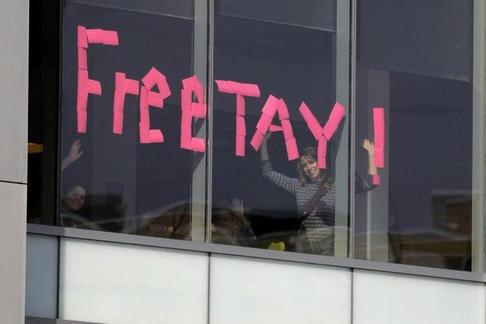 A makeshift sign goes up in an office window across from a courthouse where pop singer Taylor Swift is being sued for slander by a Denver DJ who she says groped her