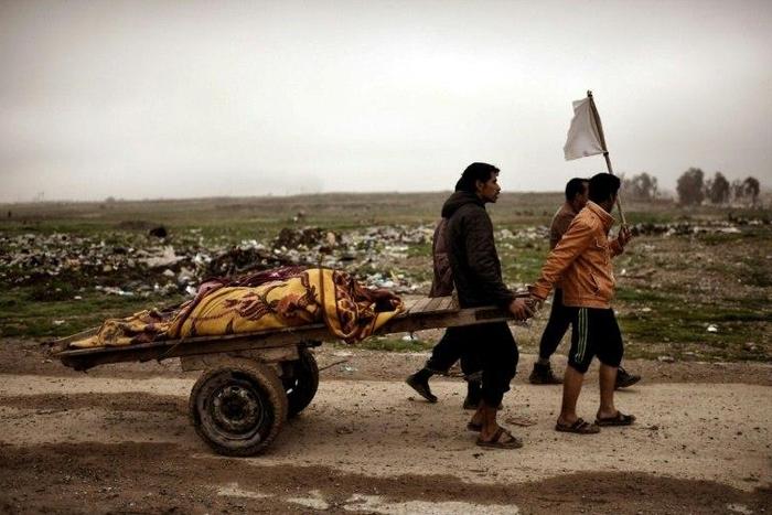 Relatives transport the bodies of west Mosul residents allegedly killed in an airstrike targeting Islamic State group jihadists on March 17, 2017
