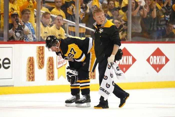 Sidney Crosby of the Pittsburgh Penguins leaves the ice with trainer Chris Stewart after taking a hit while playing the Washington Capitals on May 1, 2017