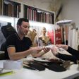 Serkan Cura, left, one of the world's top plumassiers, examines a feather design with Olivier Portais of the French wedding dress label Cymbeline