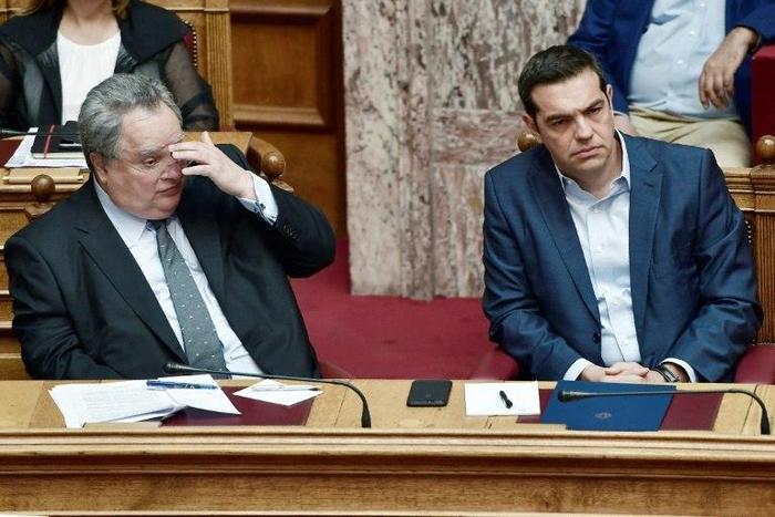 Greek prime minister Alexis Tsipras (R) and Greek foreign minister Nikos Kotzias look on during a debate on recent Cyprus talks on July 11, 2017 at the Greek parliament in Athens