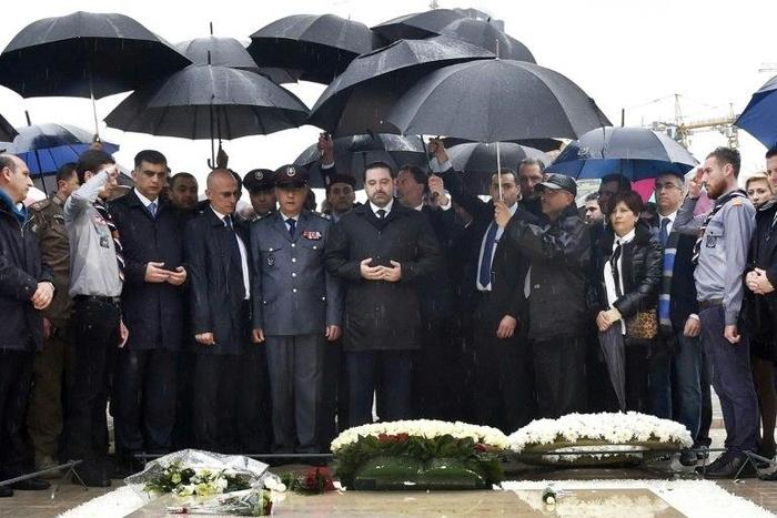Lebanese Prime Minister Saad Hariri (C) prays over the tomb of his father, slain former prime minister Rafiq Hariri, in Beirut on February 14, 2017