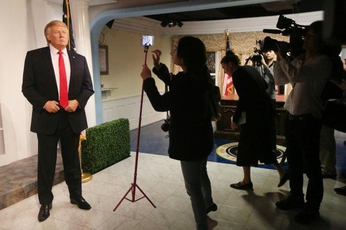 Members of the media attend the unveiling of the new wax figurine of President-elect Donald Trump (L) at Madame TussaudÕs wax museum in Washington, DC.