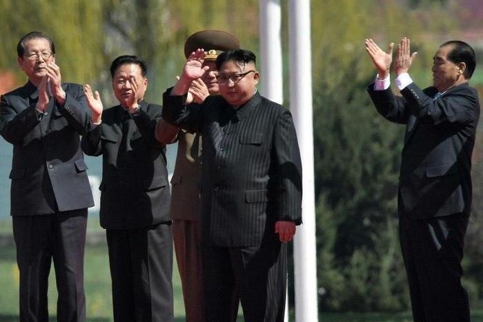 North Korea's leader Kim Jong-Un (C) waves as he attends a ceremony for the opening of a housing project in Pyongyang on April 13, 2017