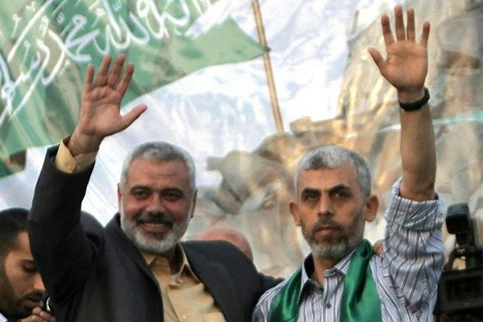 Freed Palestinian prisoner Yahya Sinwar (R), a founder of Hamas' military wing, and then Hamas leader Ismail Haniya wave as supporters celebrate the release of prisoners in Khan Yunis, southern Gaza Strip on October 21, 2011