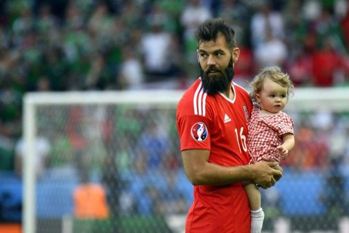 Wales' midfielder Joe Ledley and his daughter Reeva are pictured following the Euro 2016 round of sixteen football match against Northern Ireland June 25, 2016