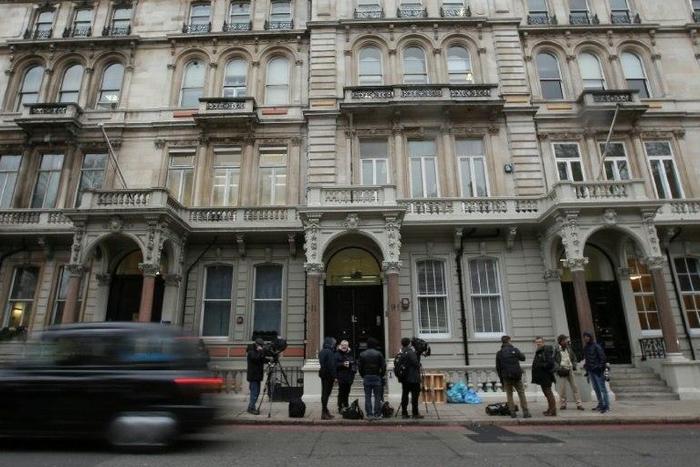 Journalists gather outside the London building housing the offices of Christopher Steele
