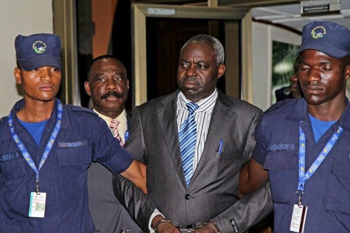 Former Hutu militia leader Bernard Munyagishari (C) is escorted by police upon his arrival at Kigali airport on July 24, 2013