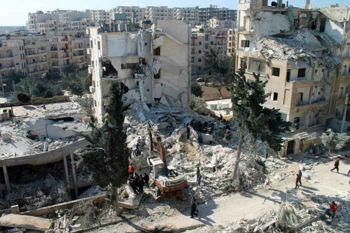 Local men and Civil Defence volunteers search for survivors amid the rubble of a building in the northwestern Syrian city of Idlib on February 7, 2017, following a reported air strike the previous night