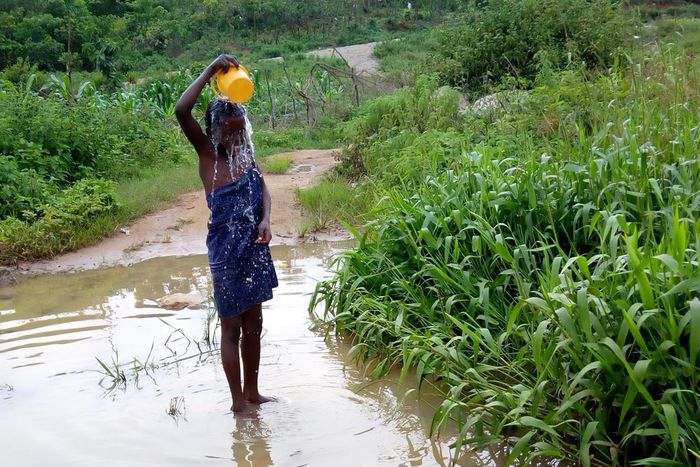Miracle, age 9 bathing at a pond close to her house