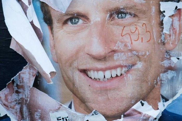 A vandalised electoral campaign poster of Emmanuel Macron in the run-up to the presidential election