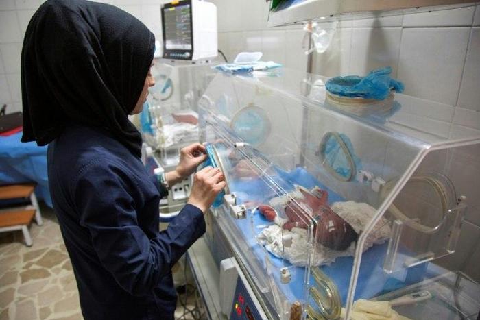 This file picture shows a Syrian nurse standing next to incubators with newborns at a children's hospital on June 9, 2016