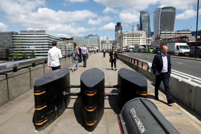 Pedestrians walk pass newly installed barriers on the pavement on London Bridge following the June 3 terror attack in London which killed seven people and injured 48.