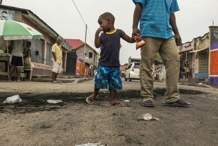 A child stares at the marks of burnt tyres following a protest in the Lingwala neighborhood in Kinshasa on December 20, 2016