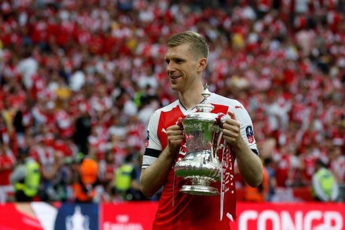 Arsenal's defender Per Mertesacker holds the trophy as he celebrates on the pitch after their win over Chelsea in the English FA Cup final on May 27, 2017