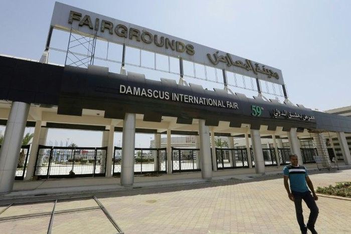 A picture taken on August 10, 2017, shows people walking past the grounds of the Damascus International Fair