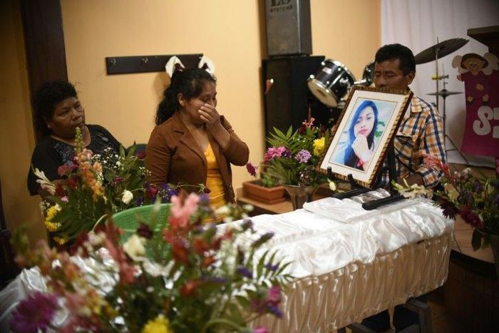 Marta Lidia Garcia (C) cries by the coffin of her 17-year-old daughter, Siona Hernandez, who died in a fire at a state-run shelter, during the wake on March 10, 2017, south of Guatemala City