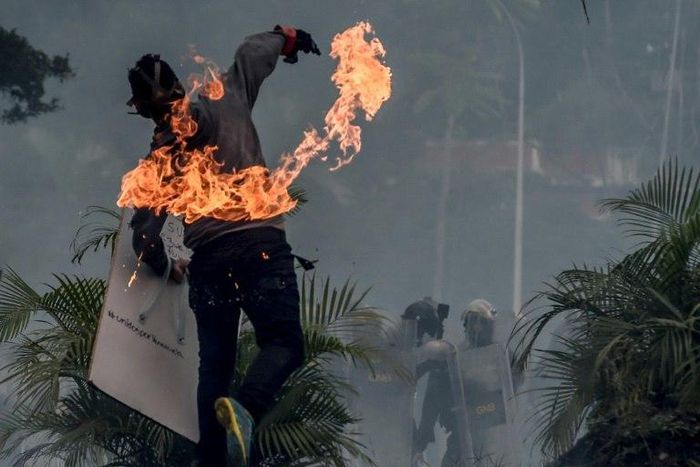 A Venezuelan opposition activist clashes with riot police during a demonstration in Caracas, on June 19, 2017