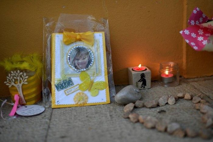 Candles and a photograph of Madeleine McCann are placed outside the church in Praia da Luz on May 3, 2017 to mark 10 years since the British girl's mysterious disappearance in the Portuguese seaside village